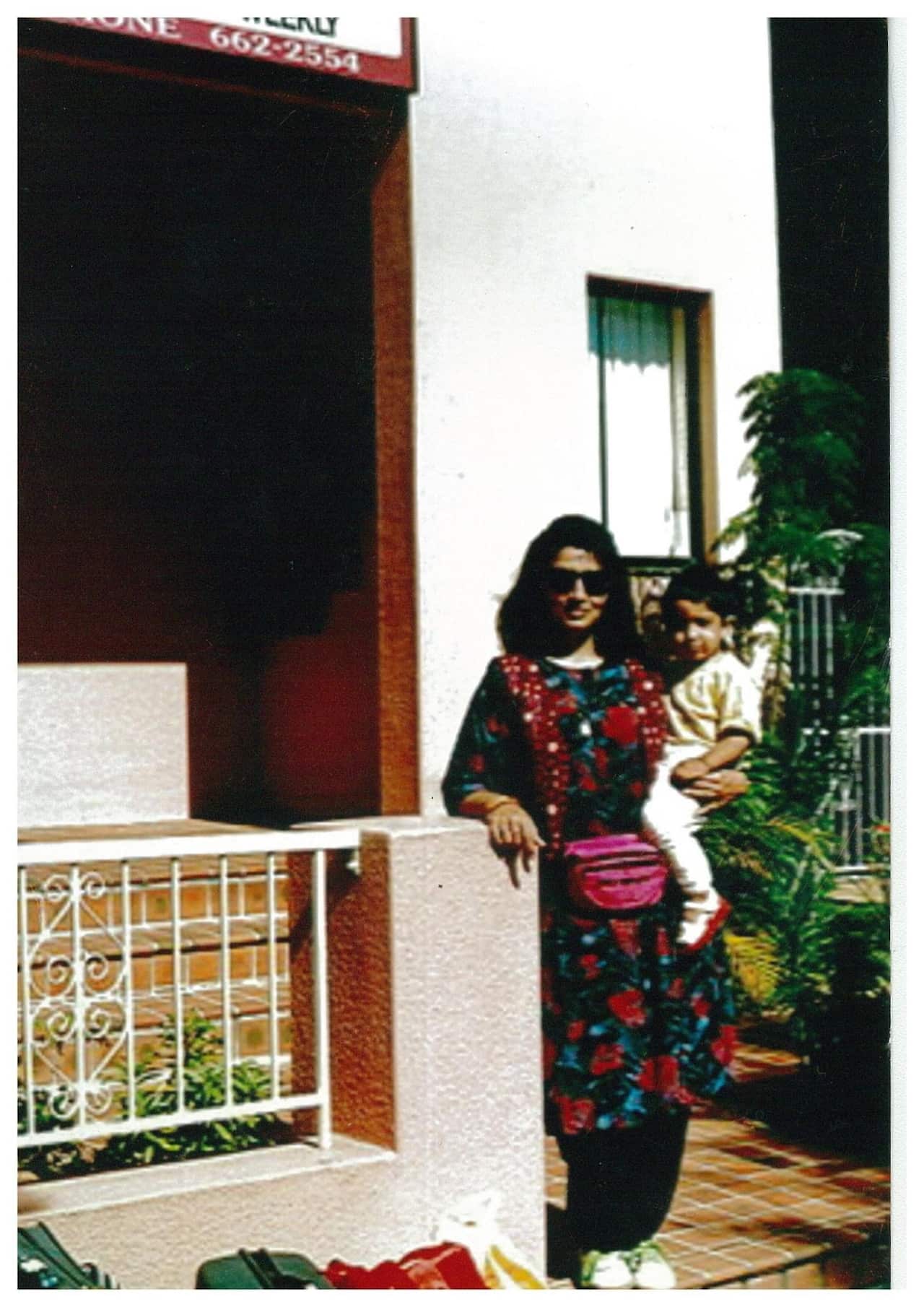 Mehreen Faruqi standing outside a house and holding a baby