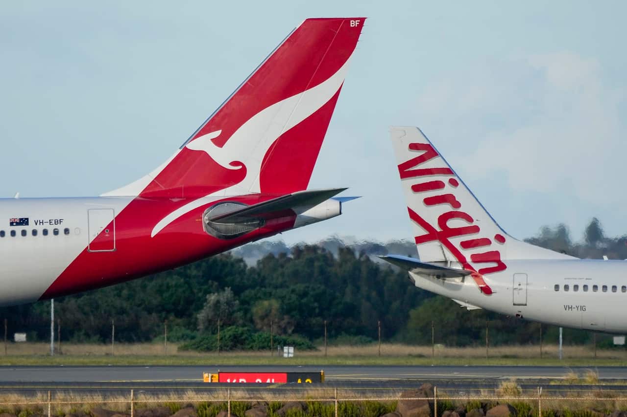 Qantas and Virgin Australia planes on the tarmac at an airport.
