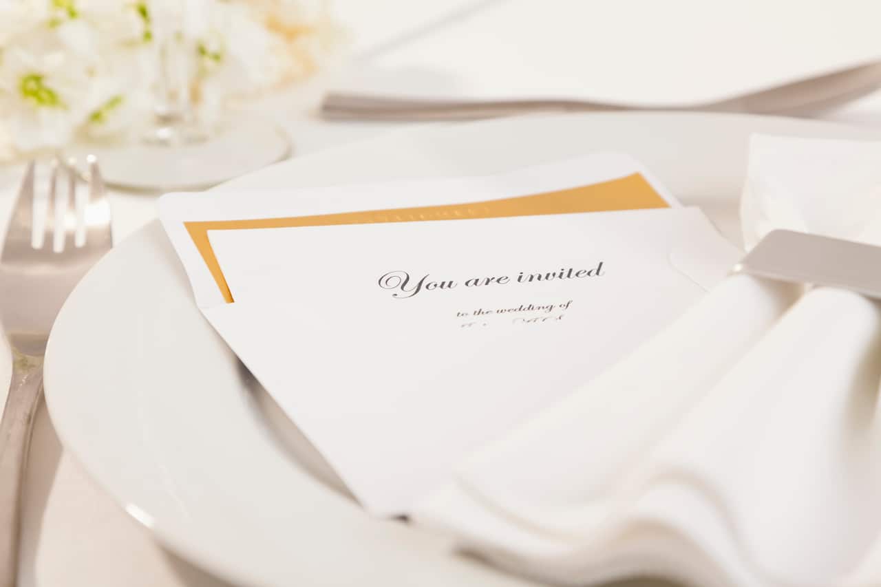 Close-up of wedding invitation on plate