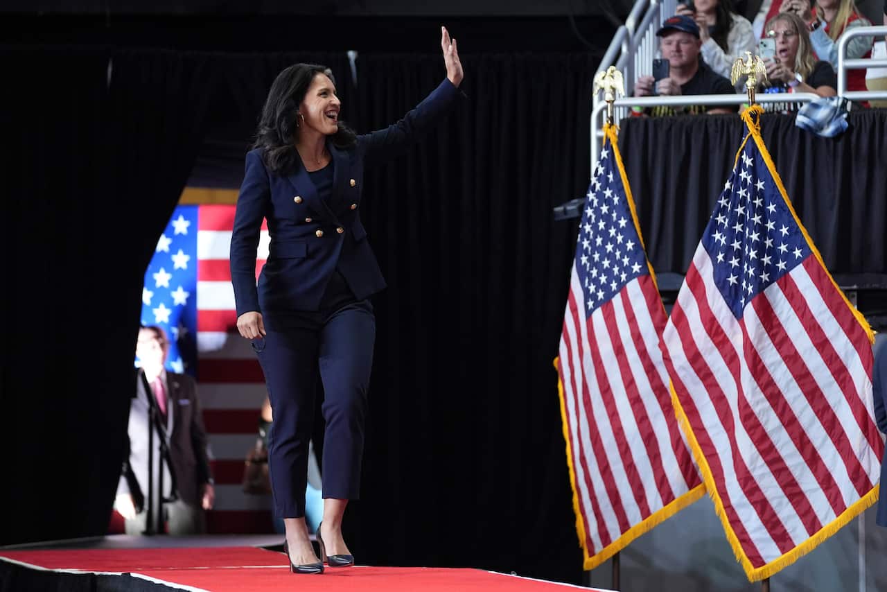 Woman walking on stage adorned with American flags.