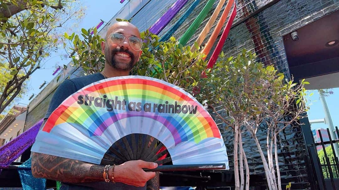 Nas Mohamed holding a rainbow coloured fan