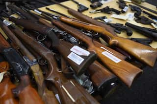 A selection of firearms laid out on a table.
