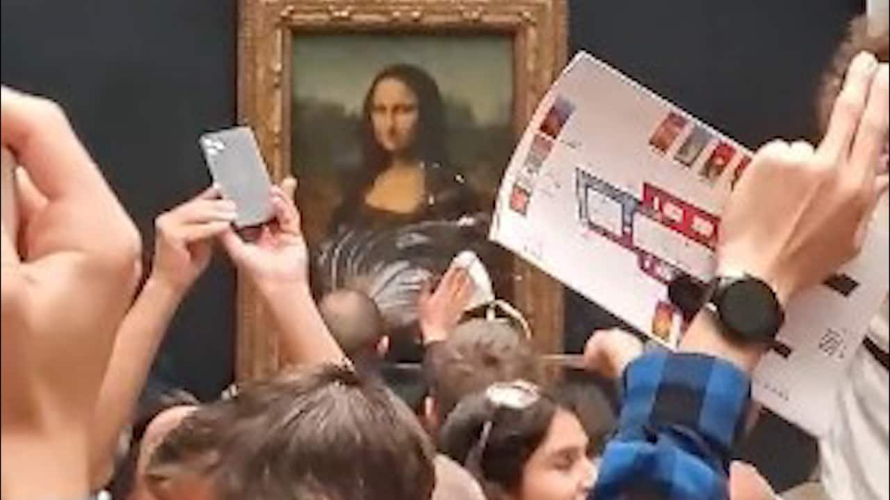 Staff cleaning protective glass covering Leonardo da Vinci's Mona Lisa painting