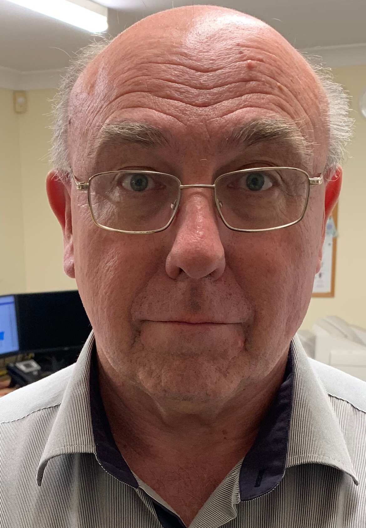 A man wearing a business shirt and glasses