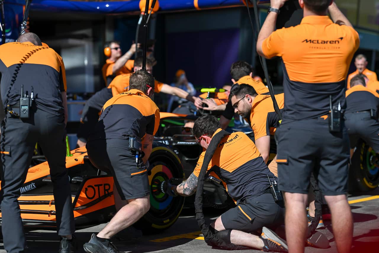 A team practices replacing tyres on a formula one car at a pit lane stop
