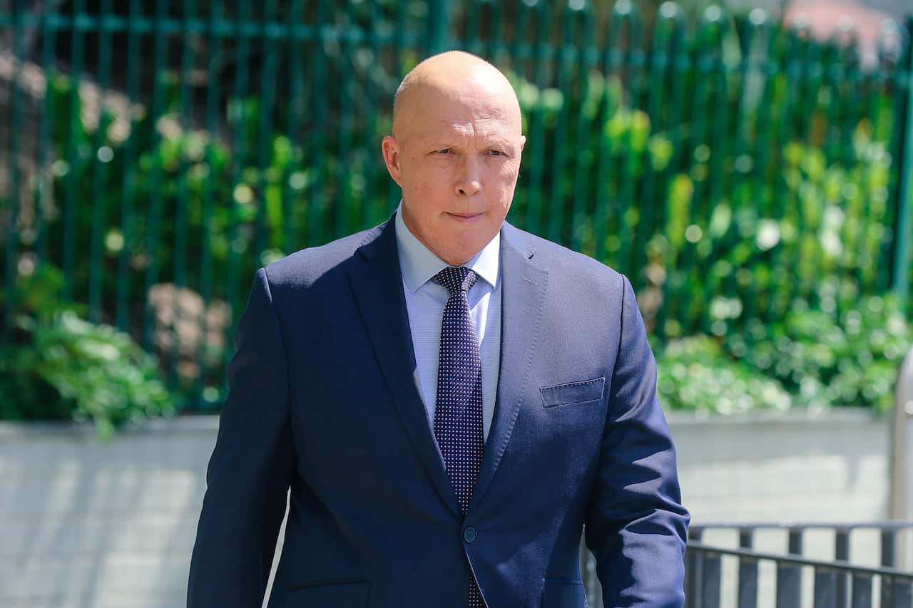 A man in a blue suit walks