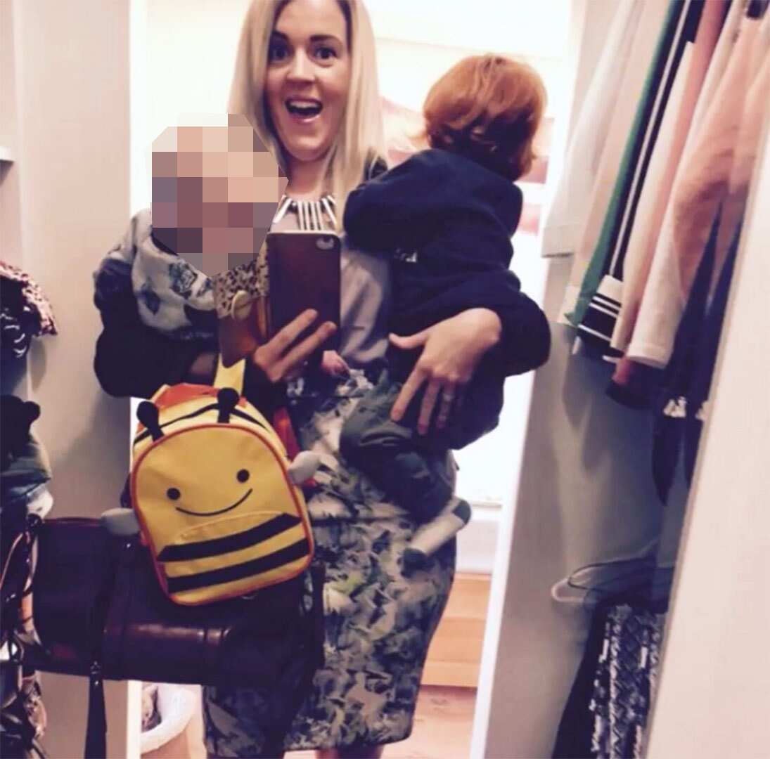 A woman carrying two children