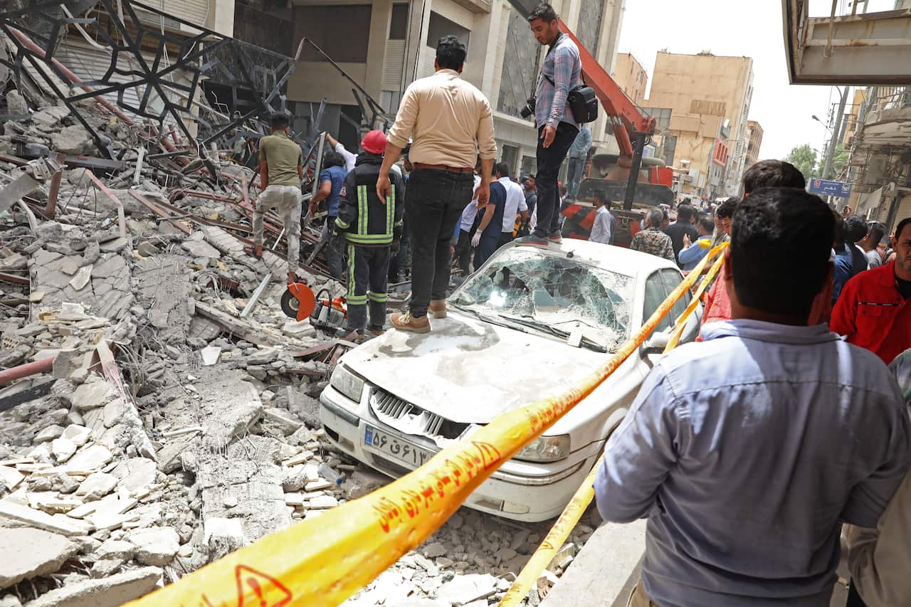 Iranians gather at the site where a ten-storey building collapsed in the southwestern city of Abadan on May 23, 2022. 