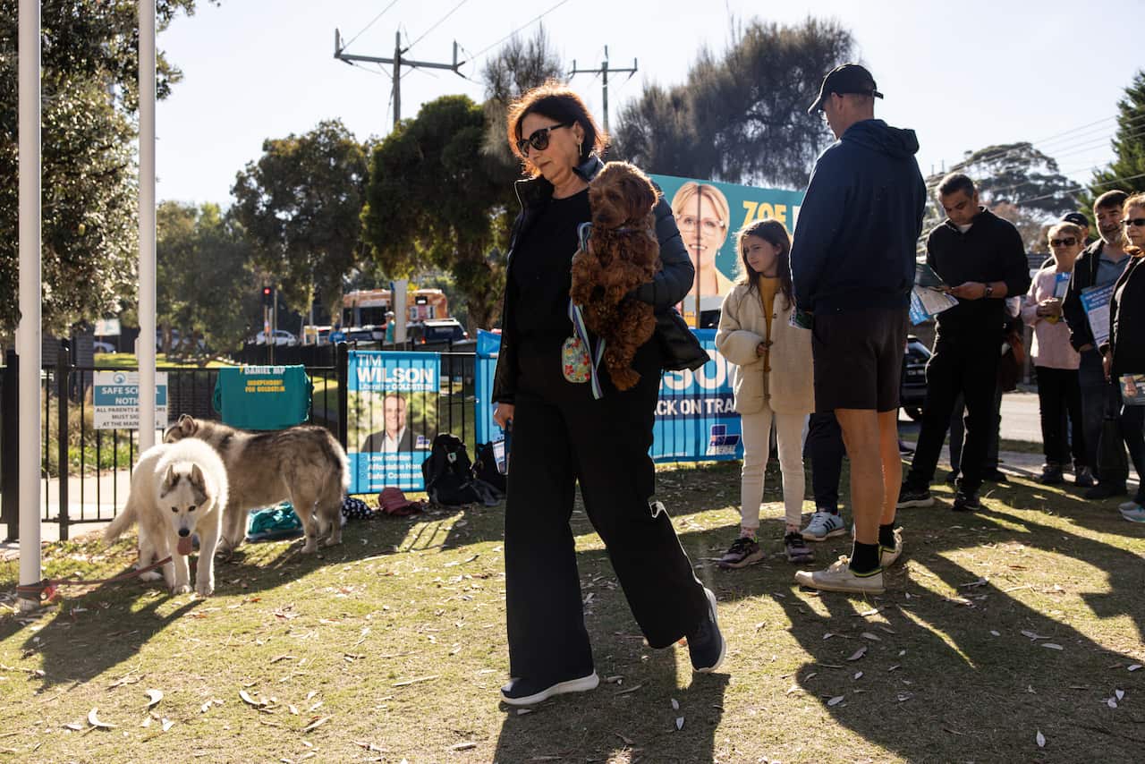 A woman carries a dog