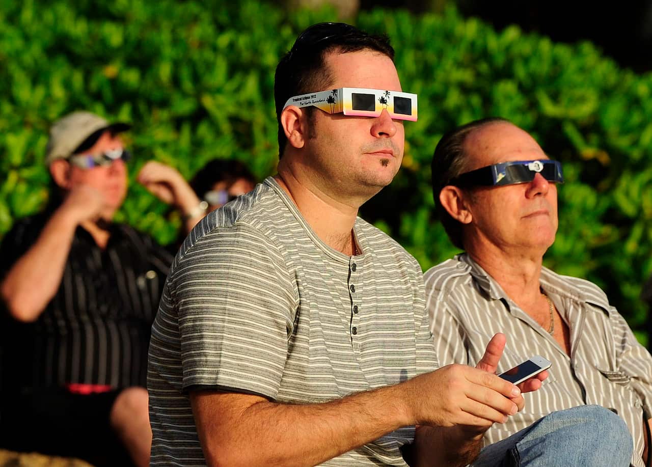 People wearing eclipse glasses outside