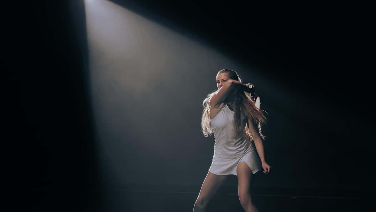 A woman swings a tennis racquet.