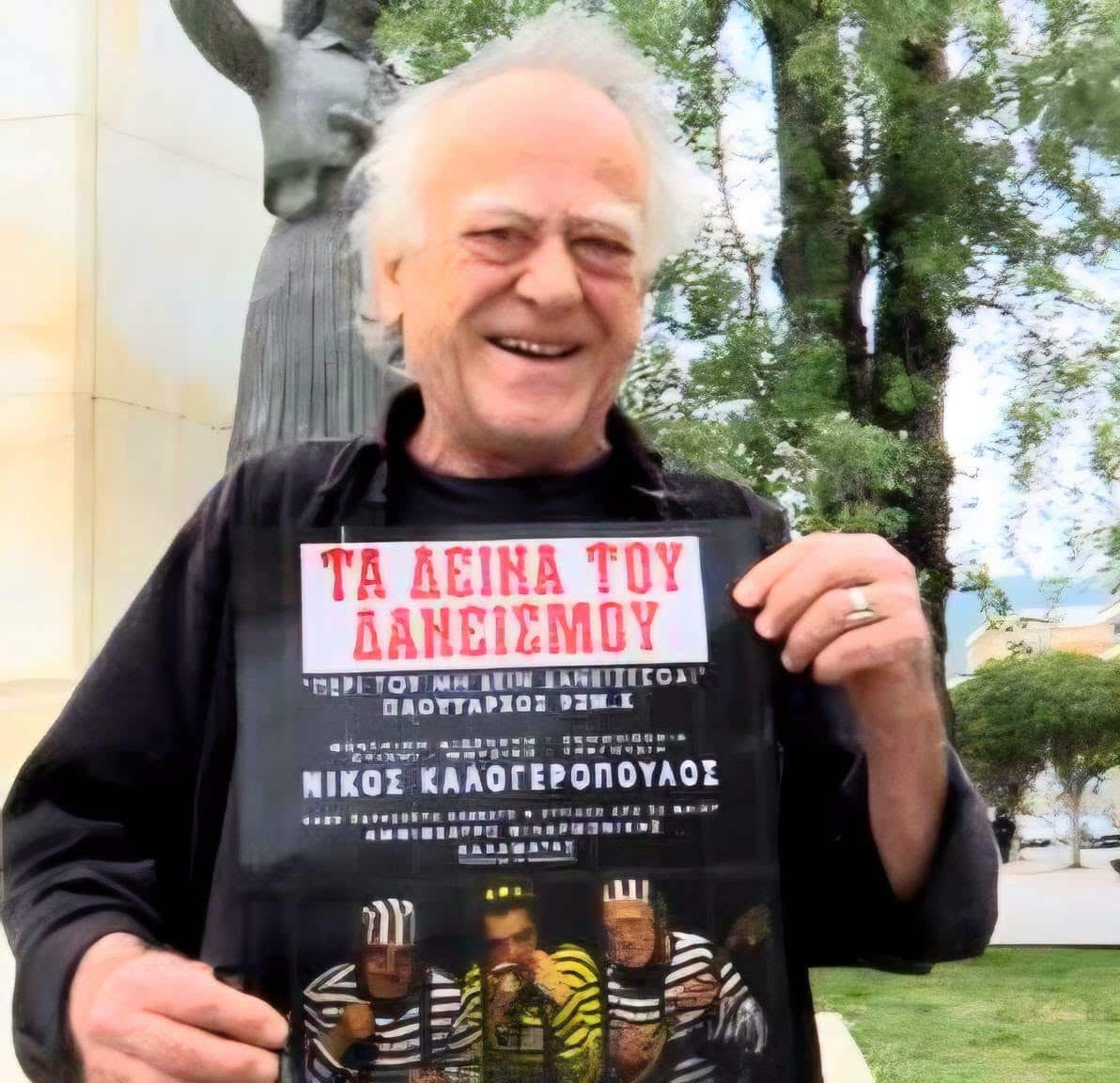 Ο Νίκος Καλογερόπουλος με αφίσα της τελευταίας του θεατρικής παράστασης