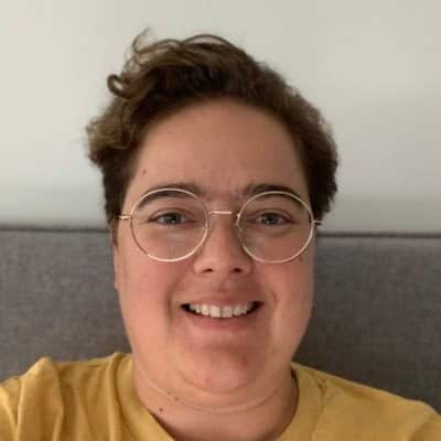 A woman wearing glasses and smiling