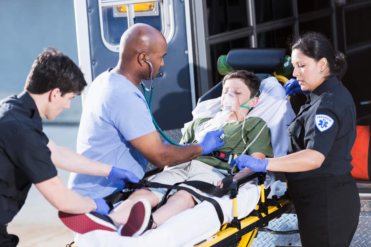 Doctor and paramedics helping child