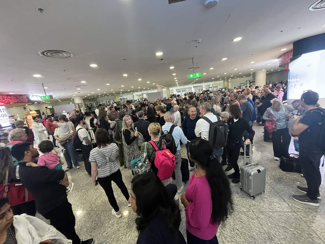 People gathered to listen to staff at the airport.