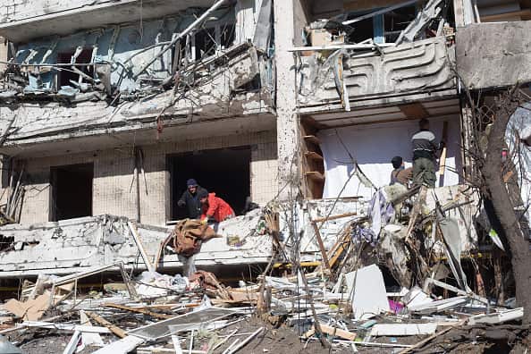 People at a residential building in Kyiv, Ukraine heavily damaged by a Russian military rocket strike.