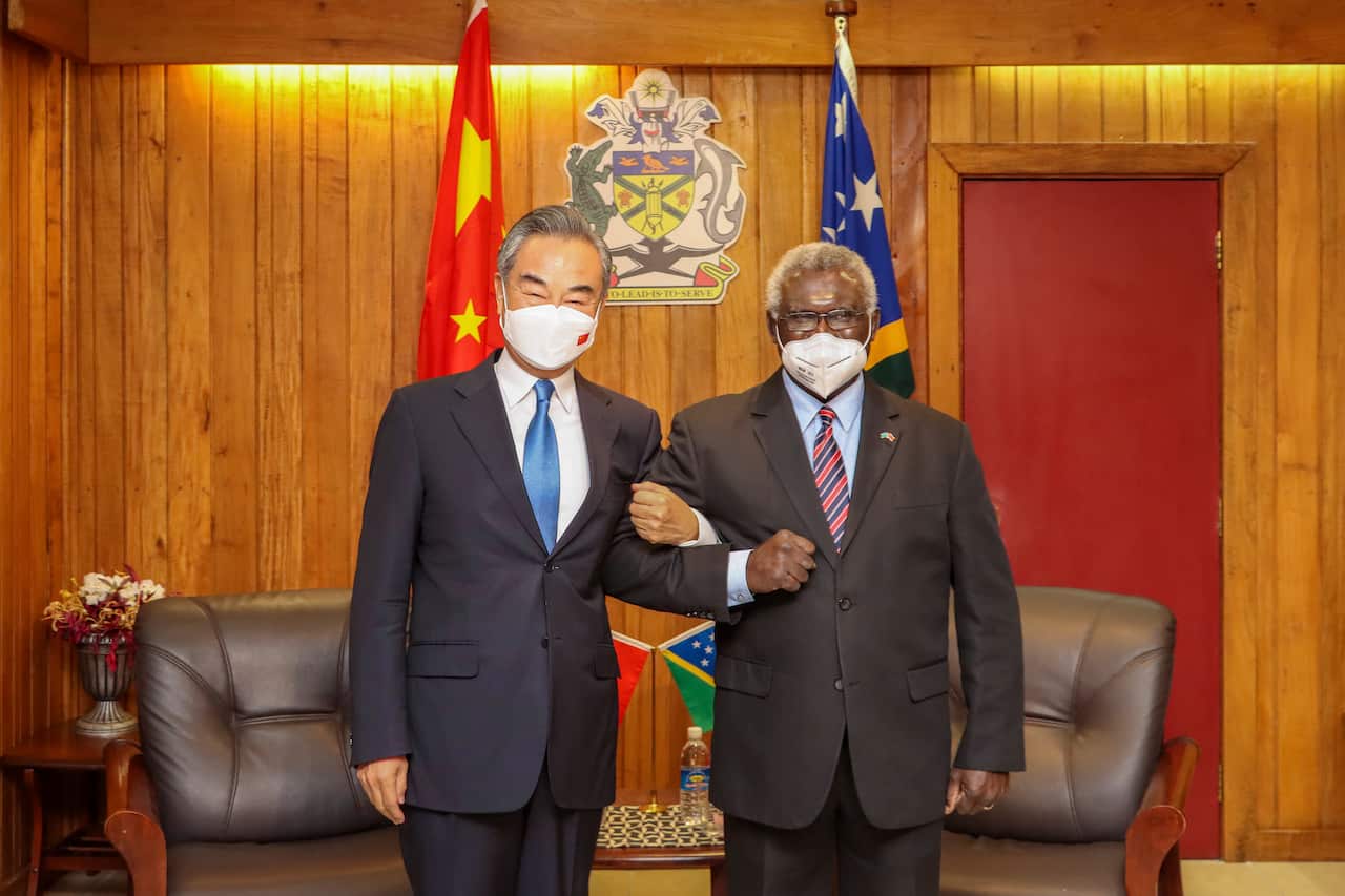 Two men wearing face masks while standing.