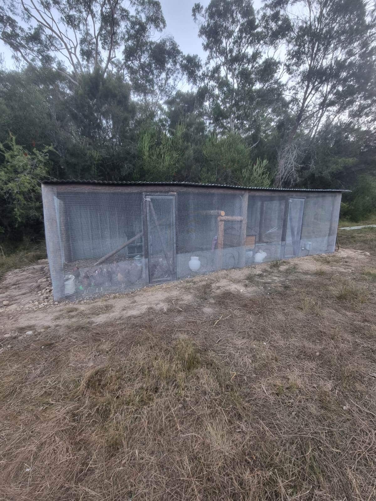 A chicken coop in some bushland.