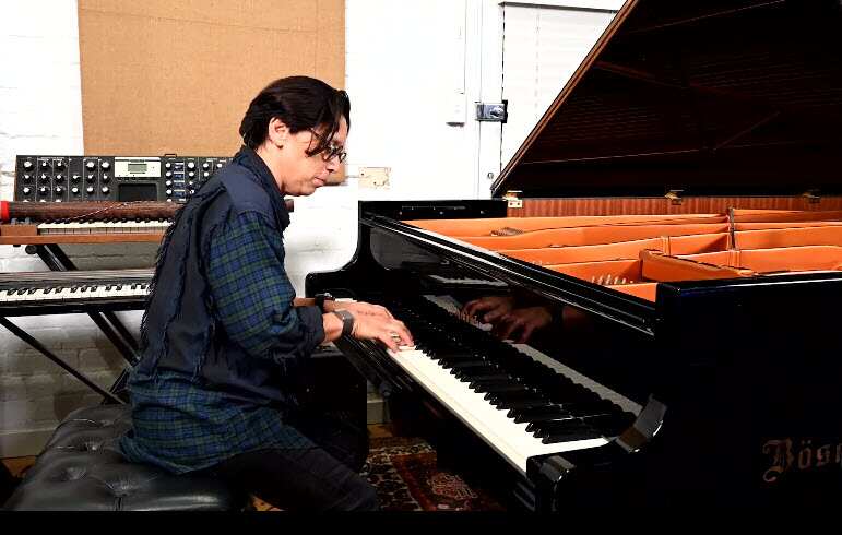 A person sitting at a piano and playing.