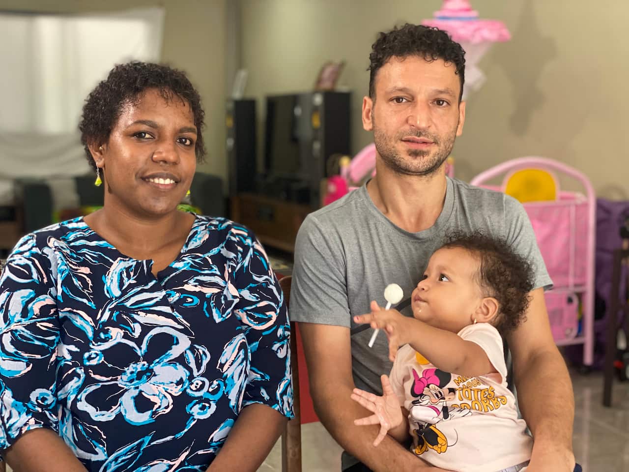 A man, a woman and a baby sitting together