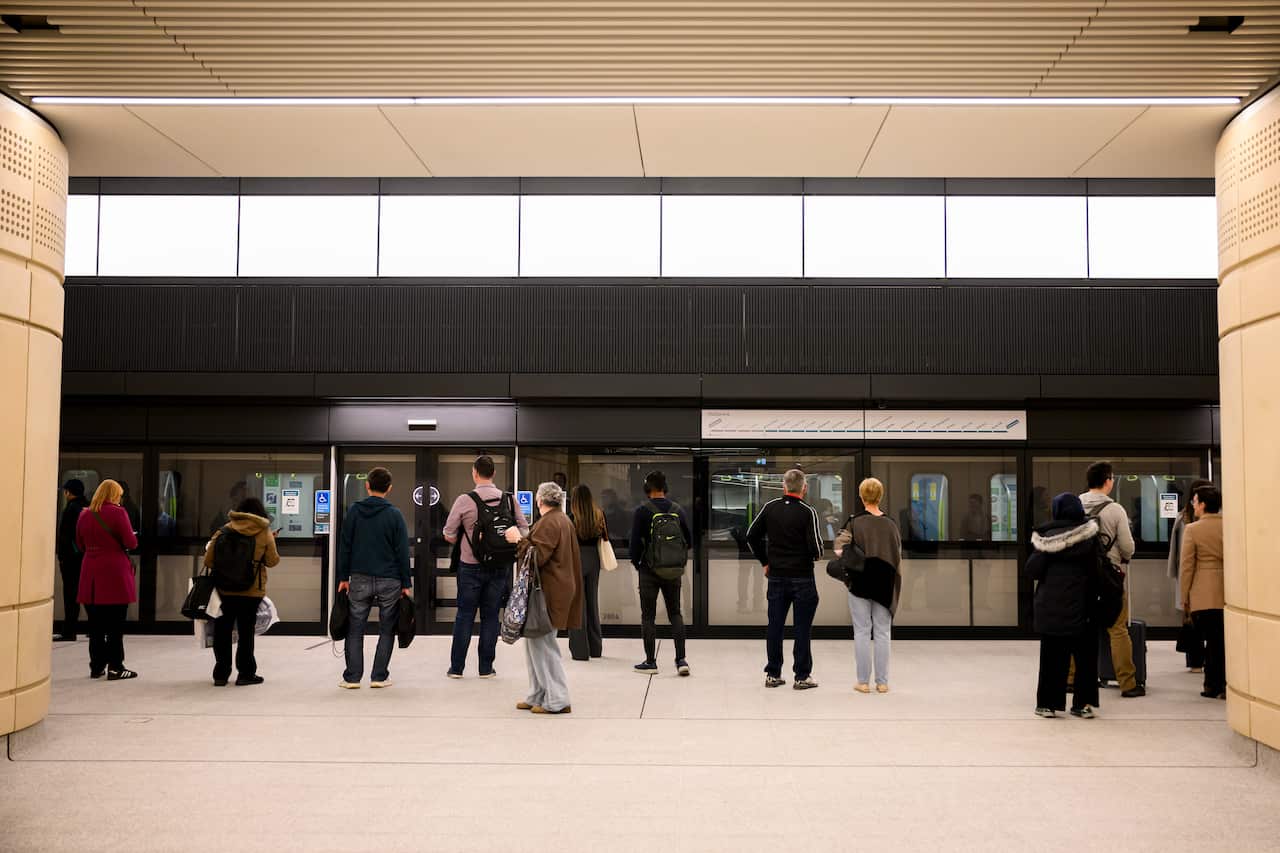 People waiting on a platform for a train.