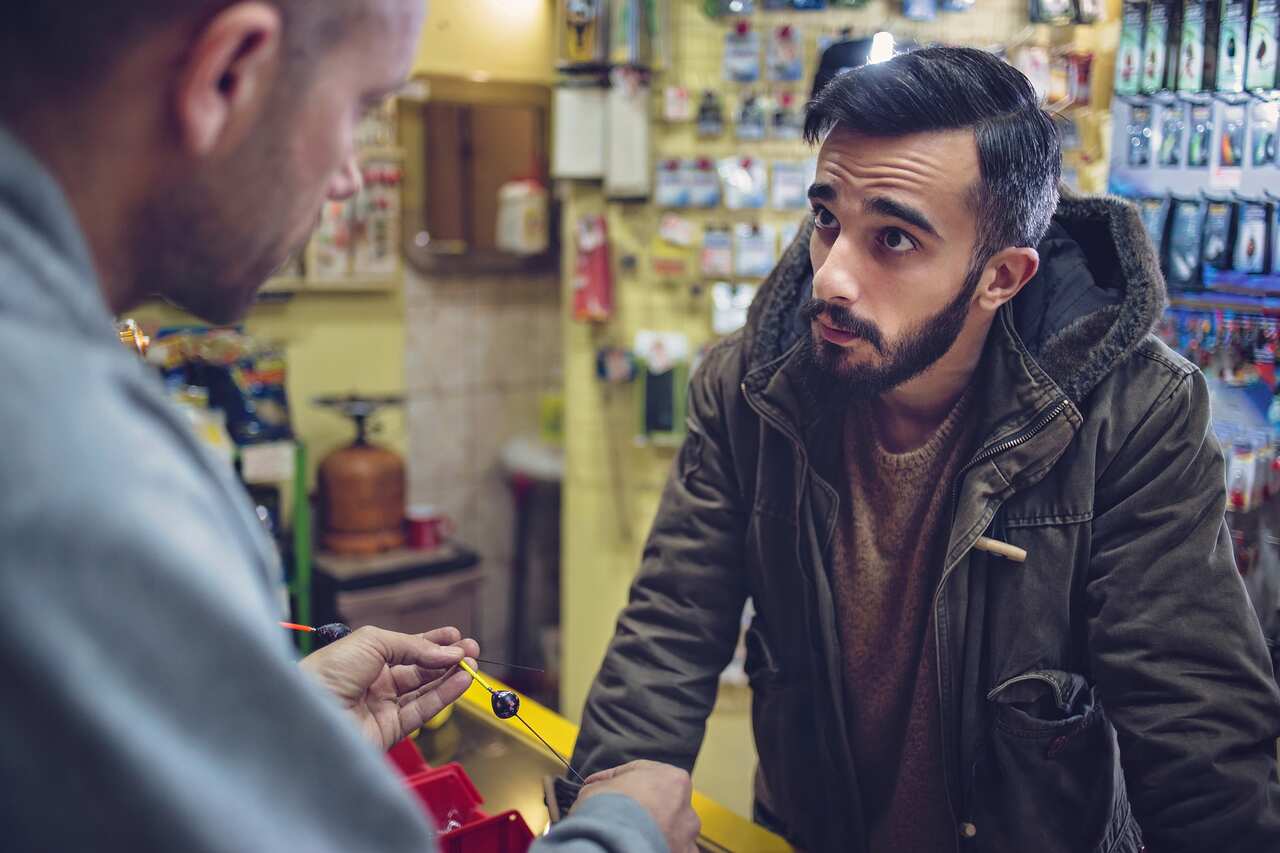 Fisherman buying fishing equipment in a store