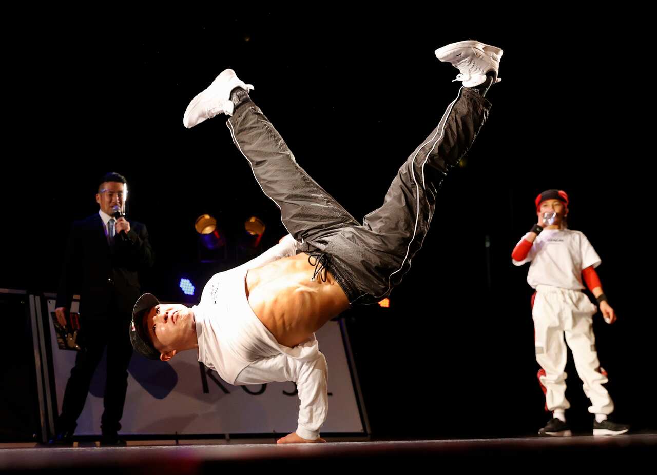 A man breakdancing on stage.