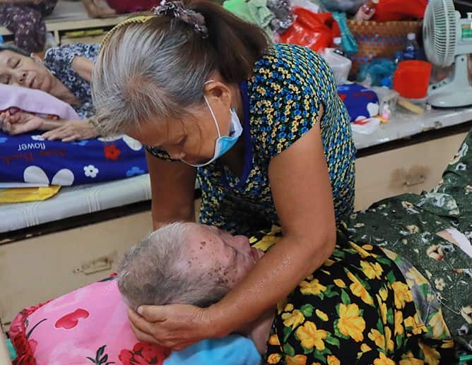 Thiện n guyện viên chăm sóc một cụ bà