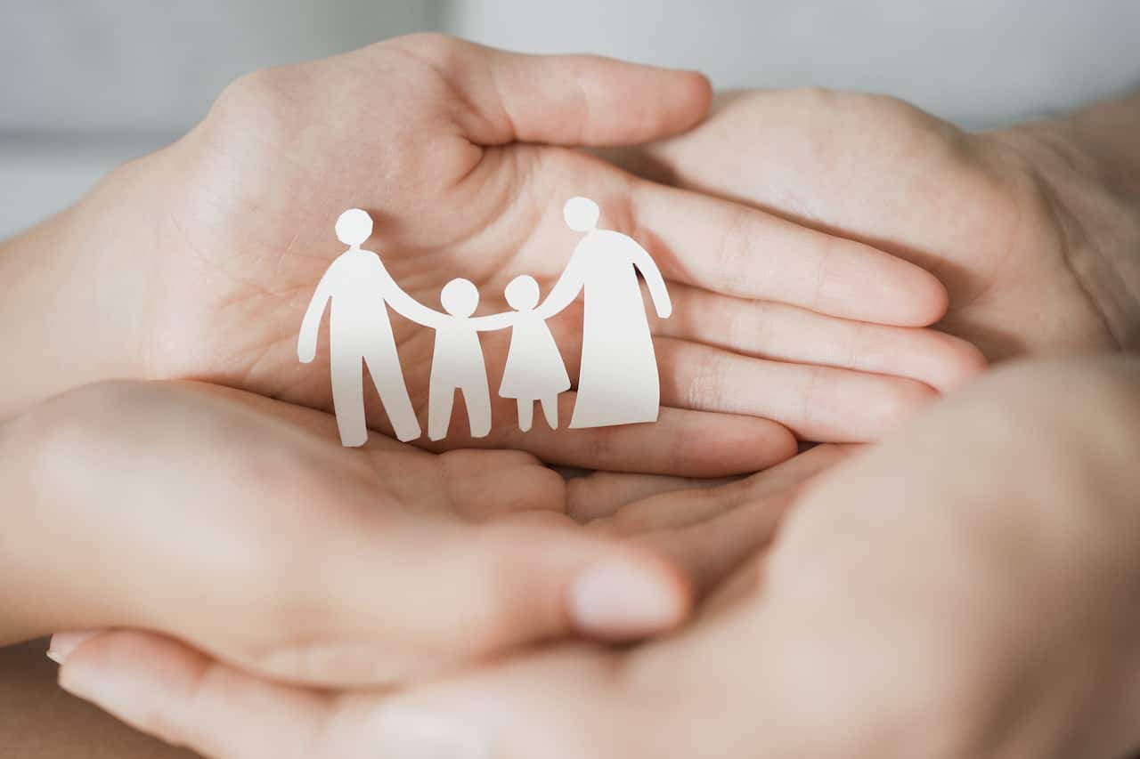 Hands holding paper family cutout, family home,life insurance, adoption foster care, homeless support , mental health, homeschooling education, Autism support, parent day