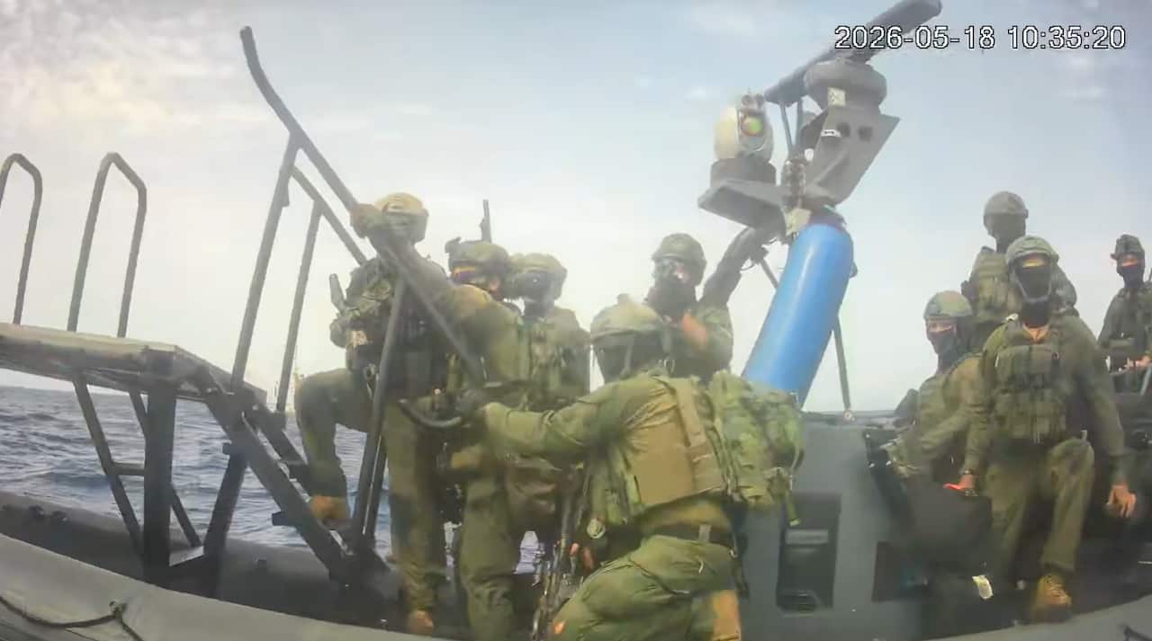 Masked men in military uniform standing on a large inflatable speedboat