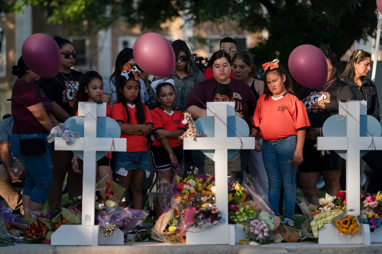 People standing at a memorial.