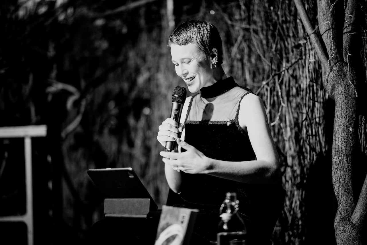 A black and white photo of a woman holding a microphone 