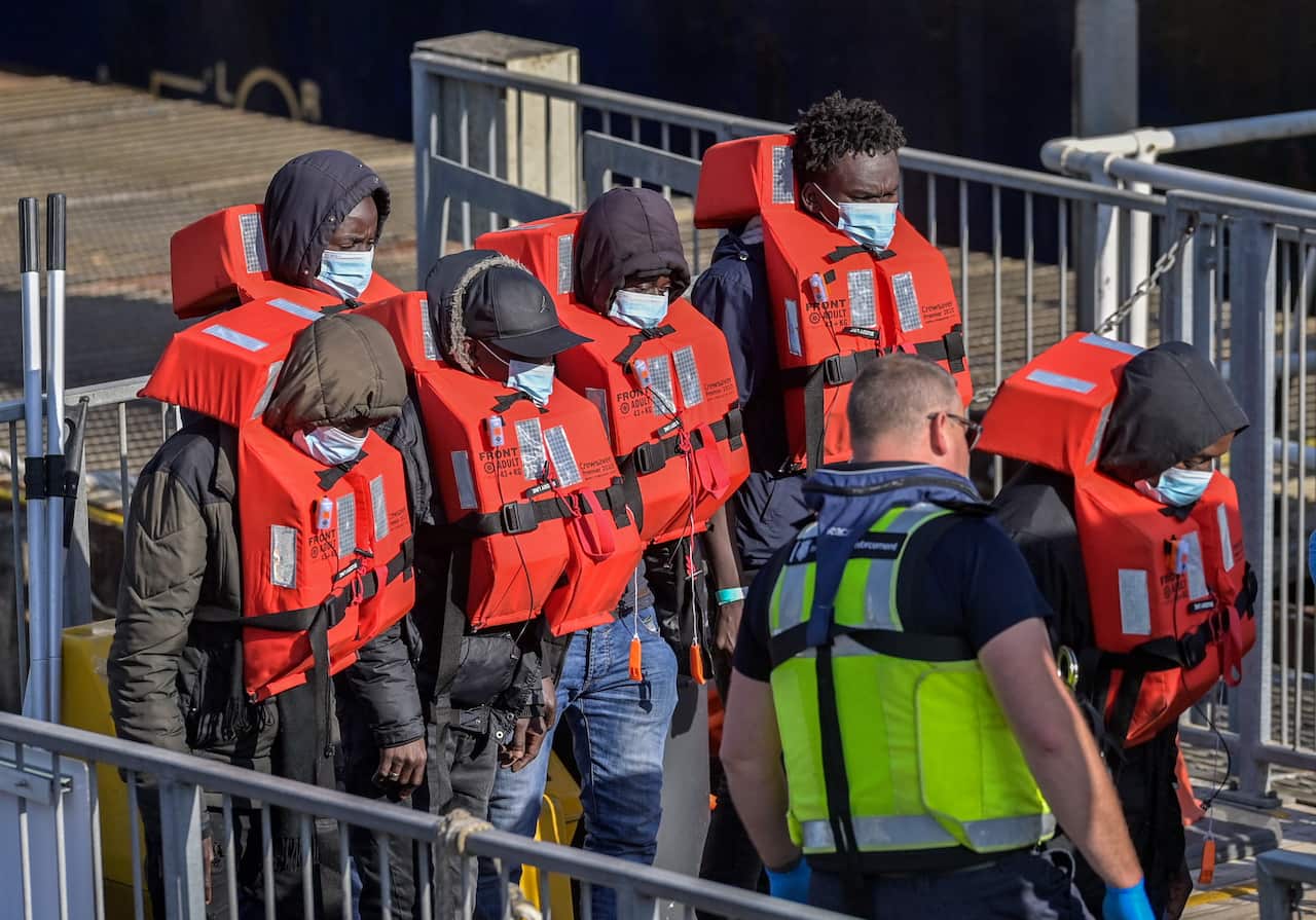 Asylum seekers prepare to disembark at Dover after UK officials intercepted the boat in the English Channel on 9 May.