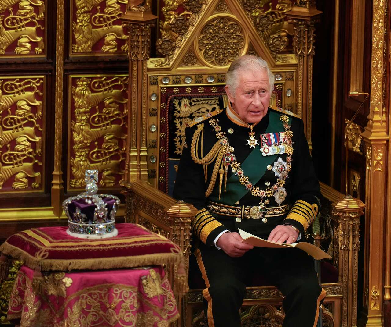 Prince Charles reads the Queen's speech seated next to her crown  in the House of Lords