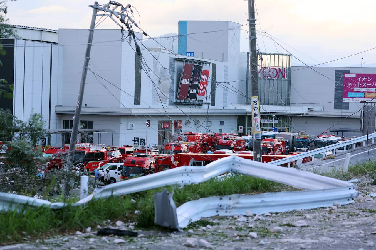 A large group of vehicles parked outside a white building.