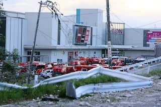 A large group of vehicles parked outside a white building.