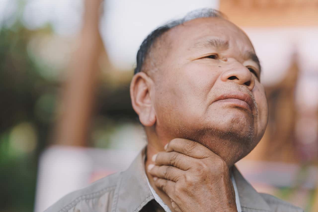 Close-up of an elderly man  - choking