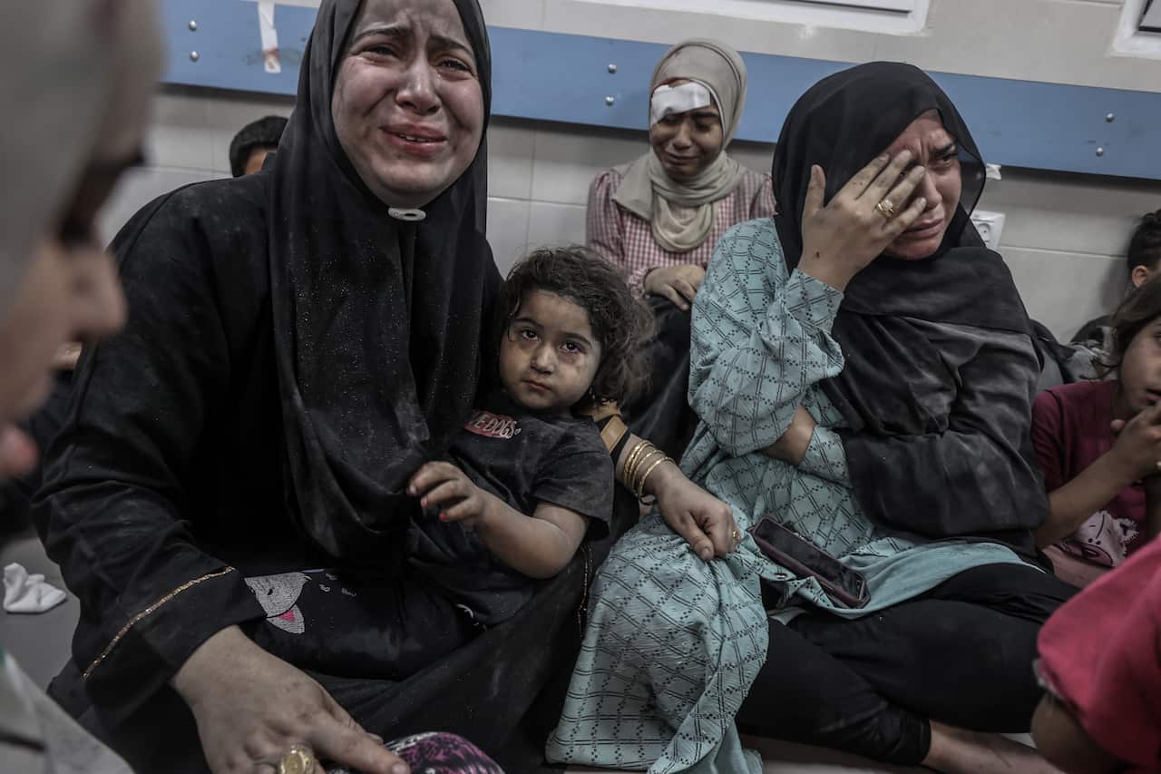 Women and children crying after a deadly airstrike on a hospital