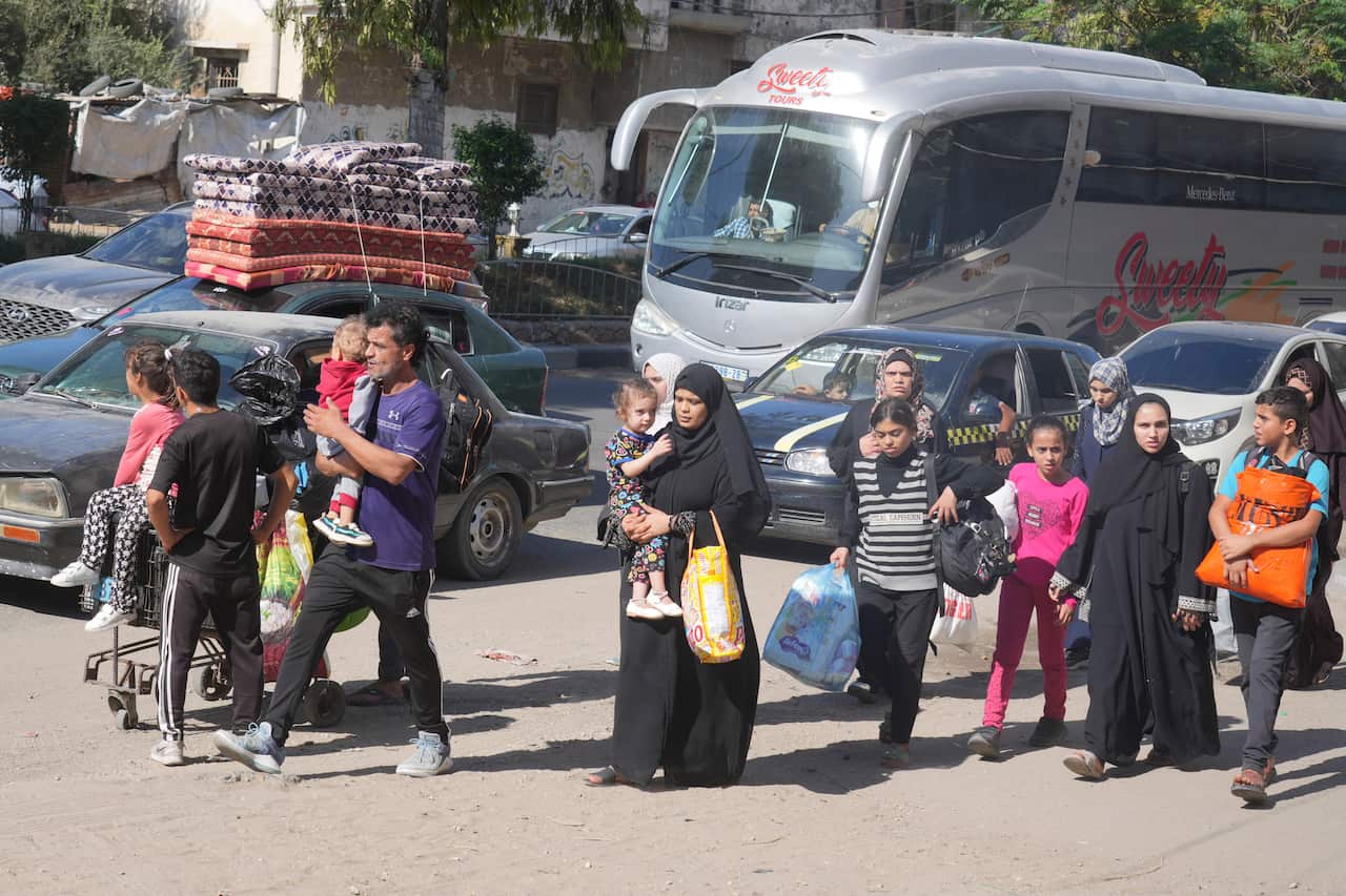 Palestinians flee, carrying bags and children