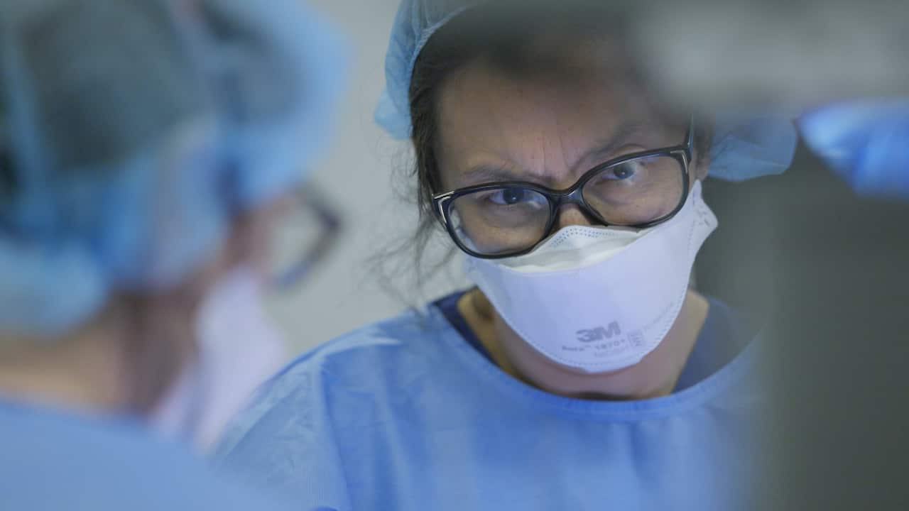 A photo of a doctor in scrubs.