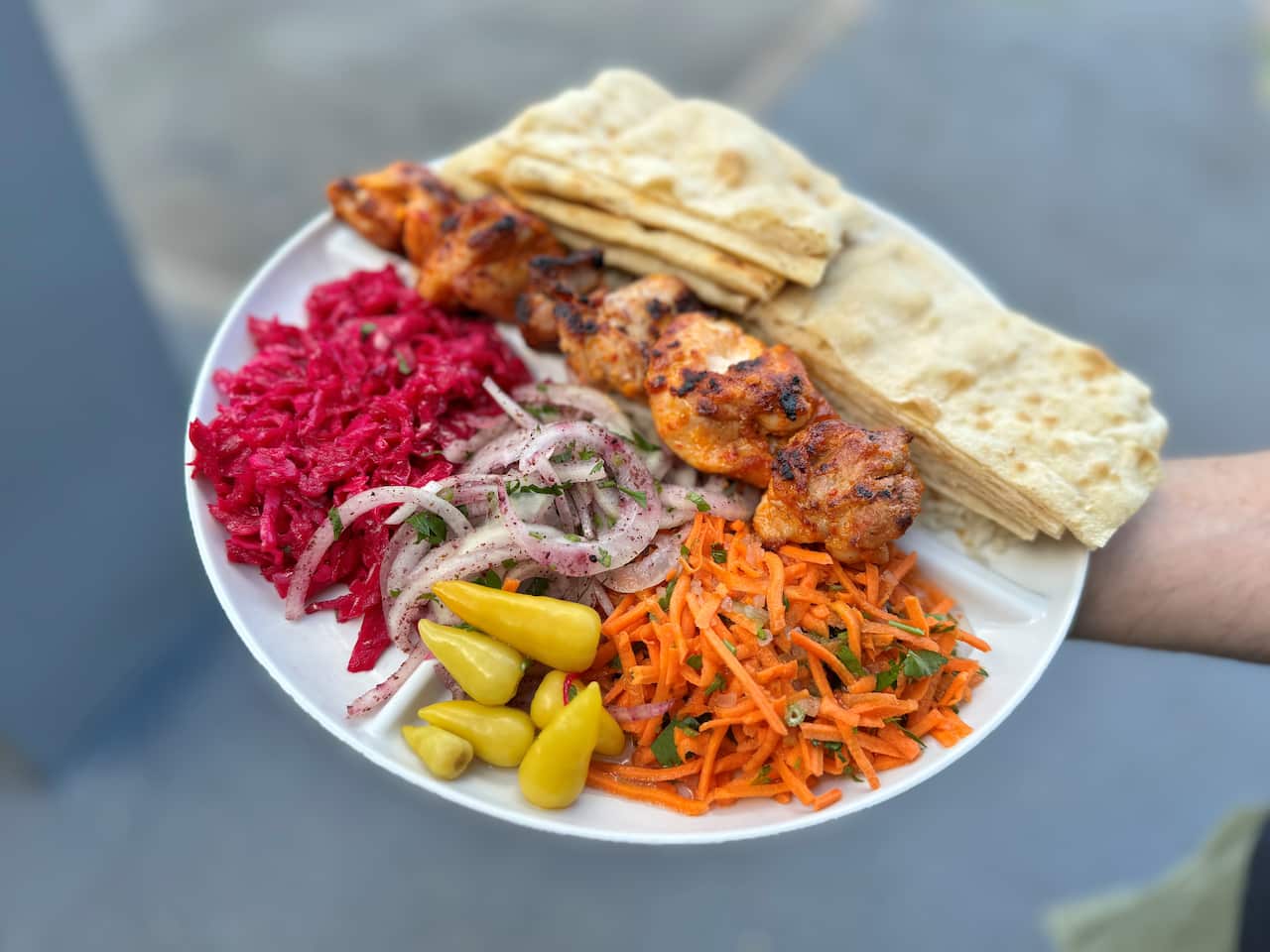 Kebab with vegetables on a white plate. 