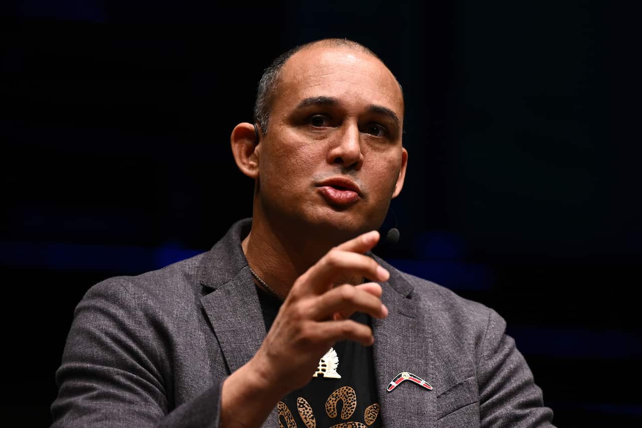 A man in a blazer speaking on stage.