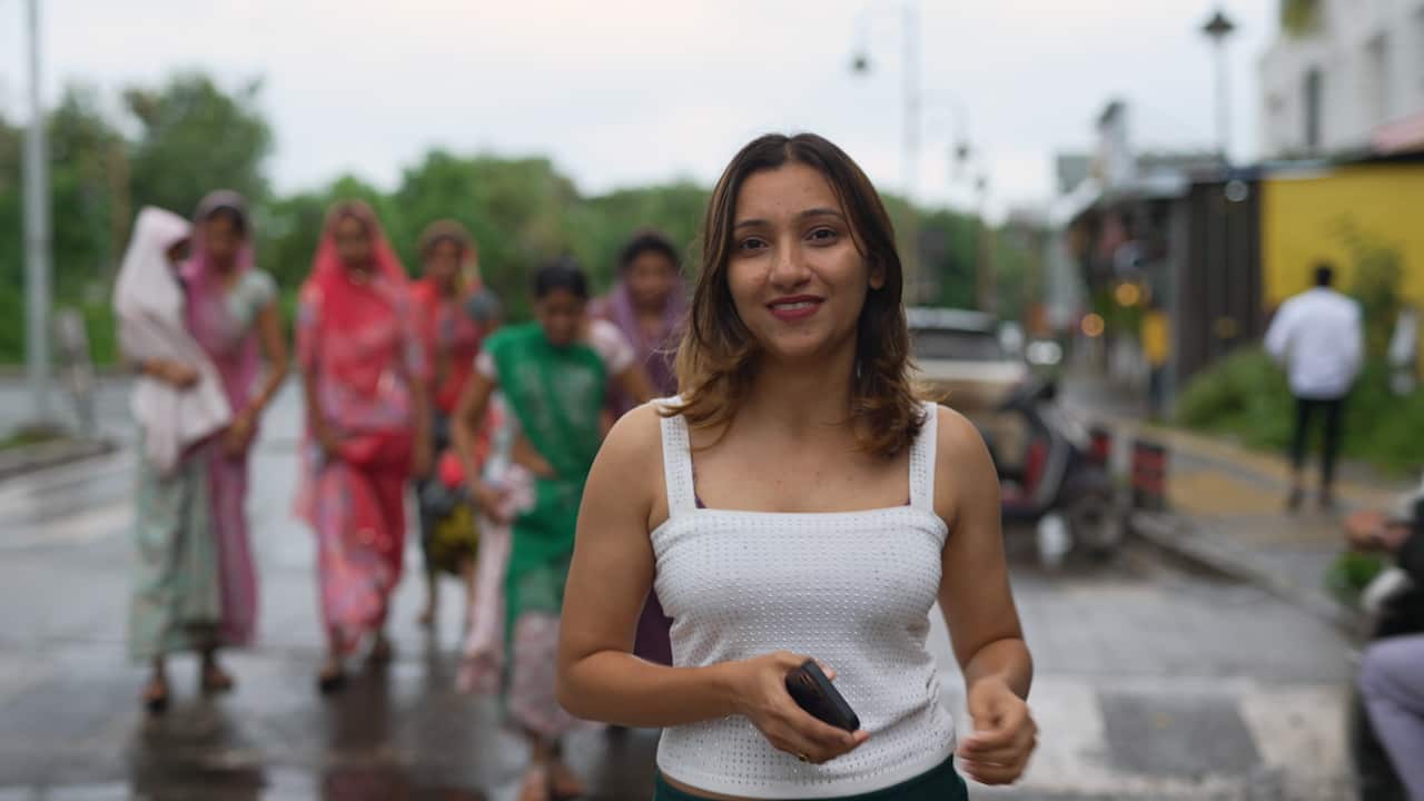 A woman wearing a white singlet outside on a street