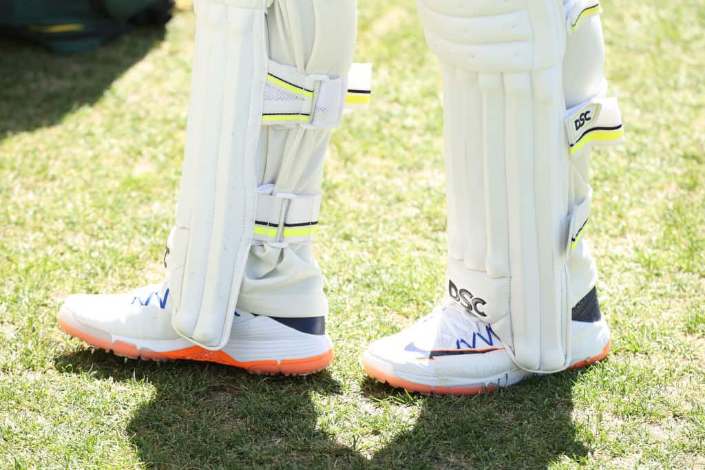 Usman Khawaja wearing white cricket shoes and pads. 
