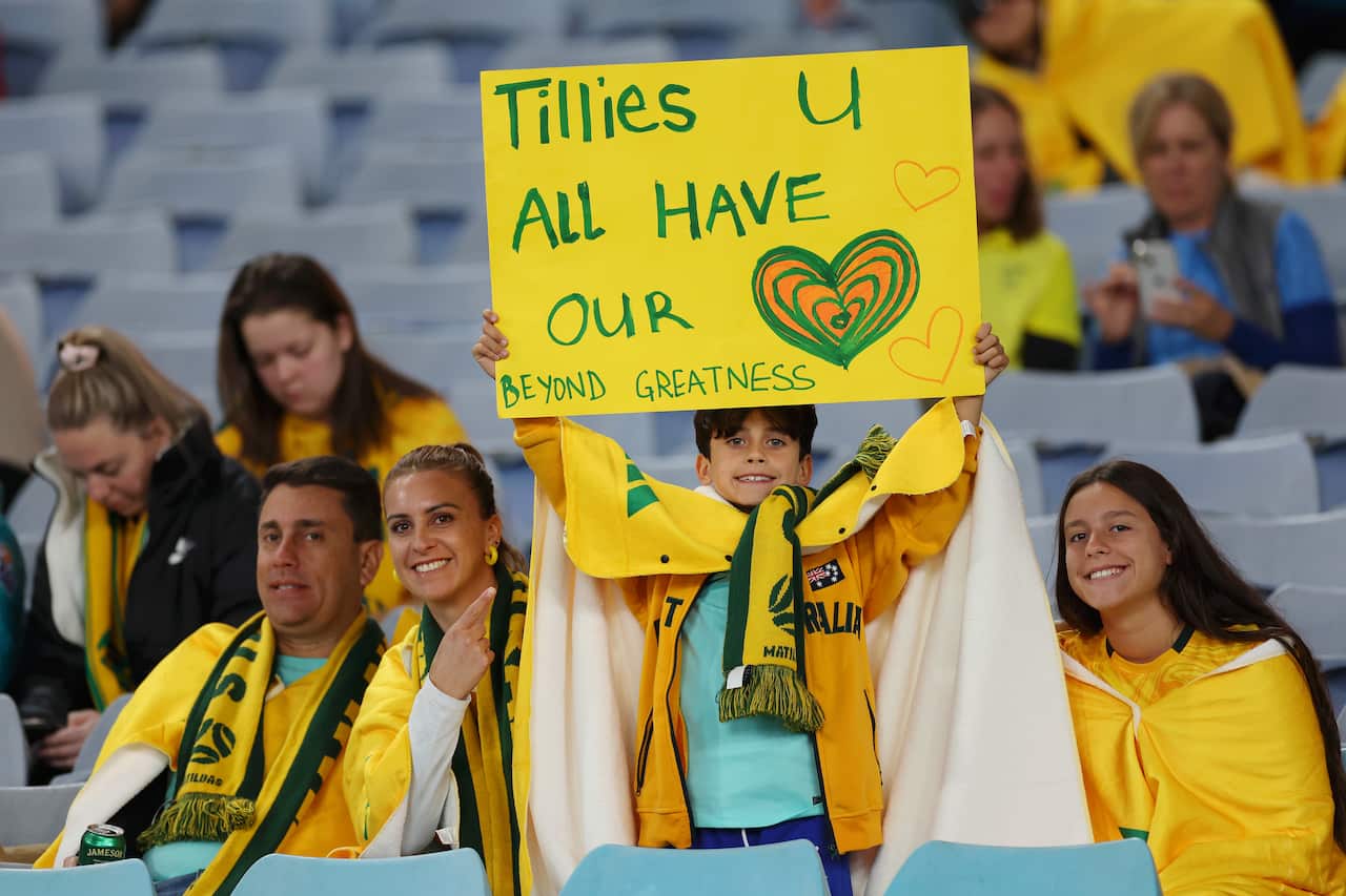 Matildas fans at Stadium Australia ahead of the match hold up a sign that reads "Tillies you all have our hearts."