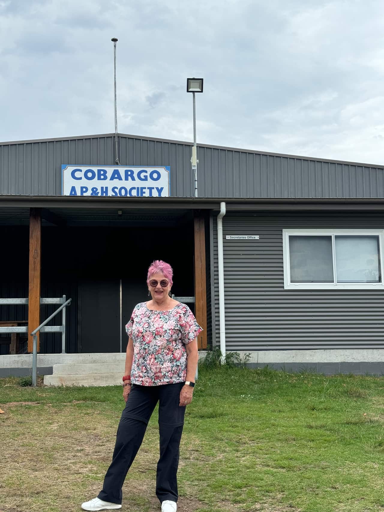 A woman standing in front of a showground.