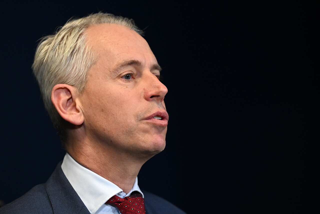 A man with grey hair against a black background.