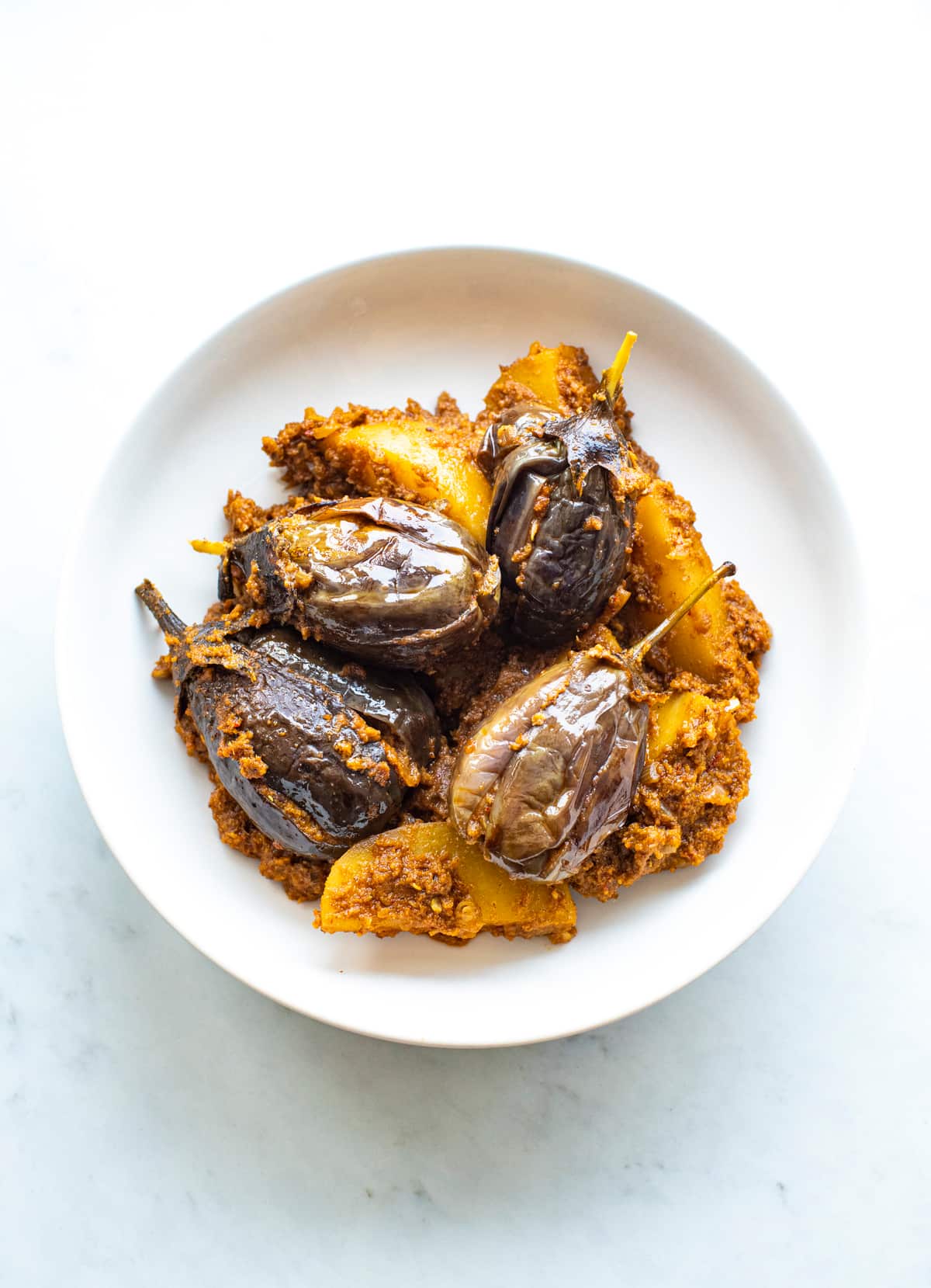 Indian eggplant dish on a white plate.