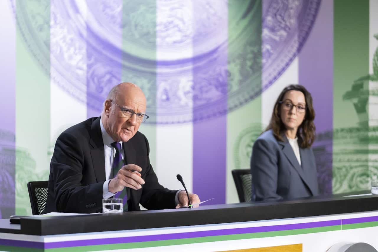 Two people sitting down while one speaks and the other listens.