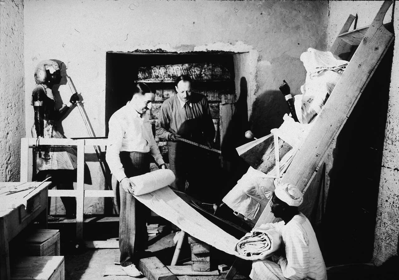 British archaeologists Howard Carter (1874 - 1939) (left) and Arthur Callender (died 1937) carry out the systematic removal of objects from the antechamber of the tomb of Pharaoh Tutankhamun, better known as King Tut, with the assistance of an Egyptian laborer, Valley of the Kings, Thebes, Egypt, 1923. (Photo by Hulton Archive/Getty Images)